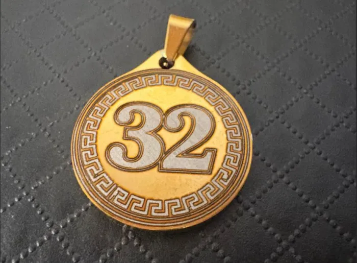Dije grabado "32"