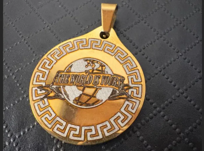 Dije grabado "The World Is Yours"