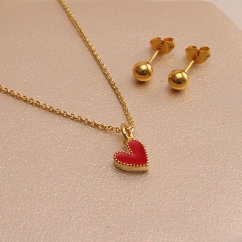 Collar con corazón rojo y aros dorados